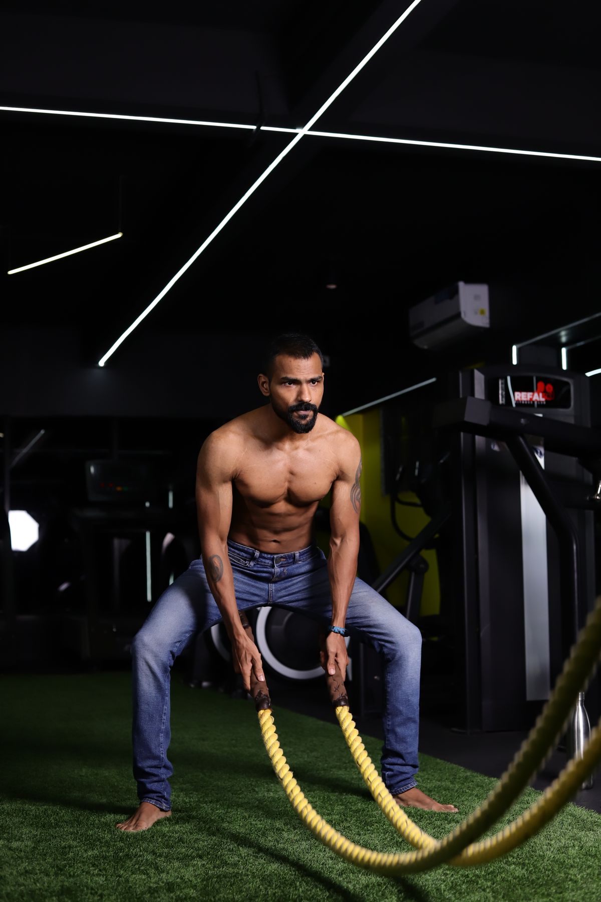Indian athlete training with battle ropes in a gym